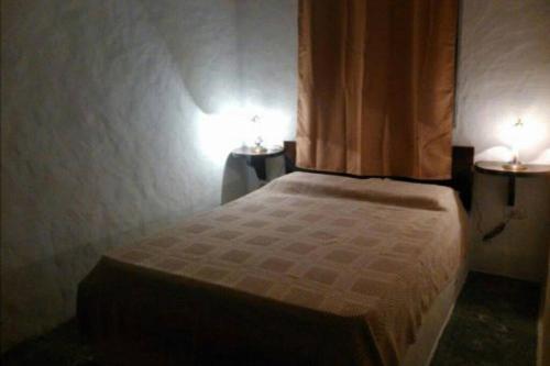 皮里亚波利斯Casa ideal para descansar Piriápolis的一间卧室配有一张带两个灯的床