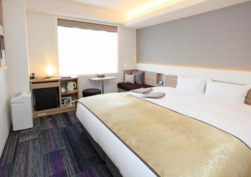 京都Urban Hotel Kyoto Gojo Premium的酒店客房设有一张大床和一台电视。