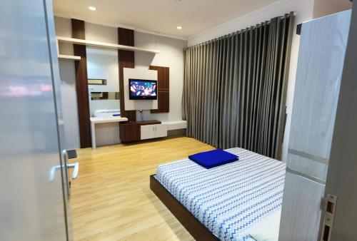 塔旺曼谷Villa Batumarta的一间卧室配有一张床和一台电视。