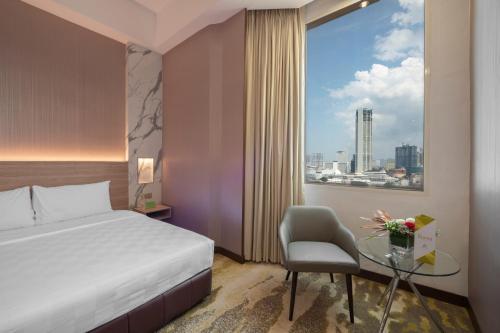 乔治市龙城槟城的酒店客房设有床、桌子和窗户。