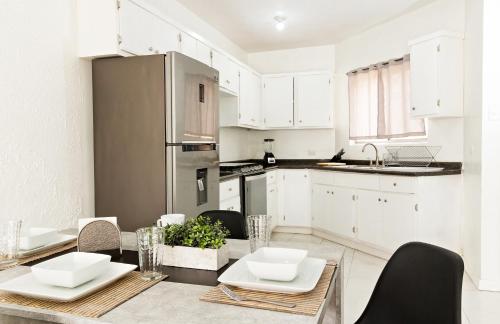华雷斯城Casa Antara的厨房配有白色橱柜和桌椅