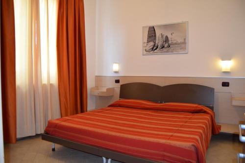 蒂勒尼亚Oasi del Mare的一间卧室配有一张带橙色棉被的床