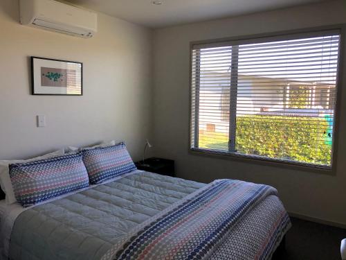 Foxton BeachNikau’s on Palmer的一间卧室设有一张床和一个大窗户