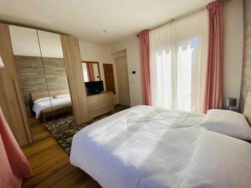 平佐洛Isabel的卧室配有一张白色大床和镜子