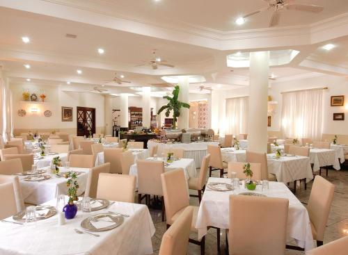 塞拉内格拉Hotel Da Vinci的用餐室配有白色的桌子和白色的椅子