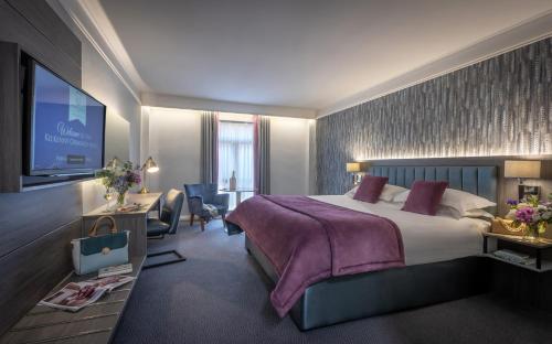 基尔肯尼基尔肯尼沃蒙德酒店的配有一张床和一台平面电视的酒店客房