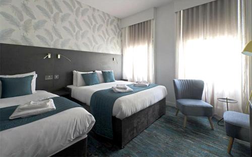 伦敦肯辛顿K酒店的酒店客房,配有两张床和椅子