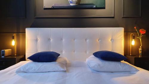 海牙城市住宿旅馆的一张带两个蓝色枕头的白色床