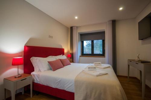 Castelo de PaivaQuinta Vilar e Almarde的一间卧室配有一张大床和红色床头板