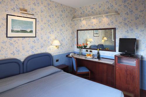 博洛尼亚诺弗德尔珀特酒店的一间卧室配有一张床和一张带镜子的书桌