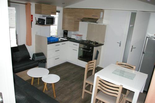 翁赞mobil home 32 m² 4/6p的小厨房以及带桌椅的用餐室。