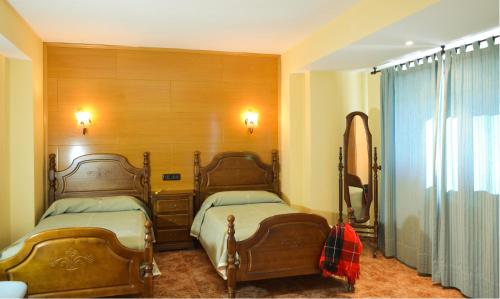 布龙查莱斯西扎酒店的一间卧室配有两张床和镜子