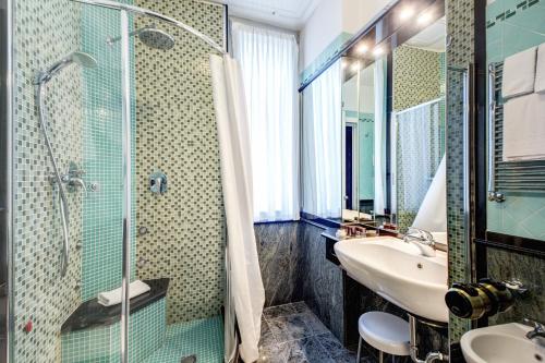 米兰布鲁内列斯基酒店的一间带玻璃淋浴和水槽的浴室