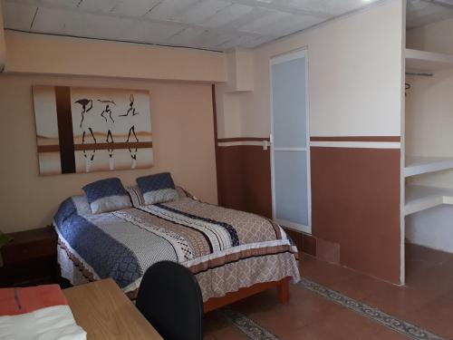 贾拉普La Casa Azul Hostal y Pension - Coatepec的一间卧室配有一张床和一张桌子
