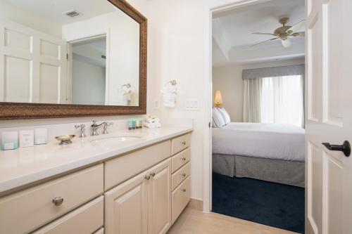 那不勒斯贝拉塞拉酒店的一间带水槽和镜子的浴室以及一张床