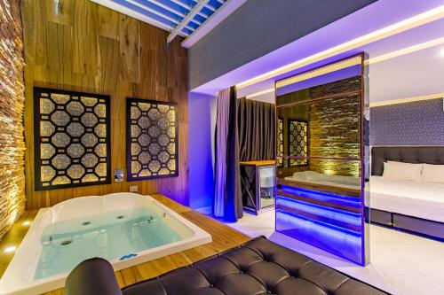 巴西利亚Drops Motel Brasília的带浴缸和床的客房
