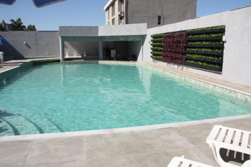 伊瓜苏伊瓜苏夫兹酒店的一座大型游泳池,在一座建筑前设有两把白色椅子
