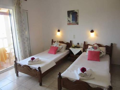 ArgyrádesAris Paschalia Studios的配有粉色和白色枕头的客房内的两张床