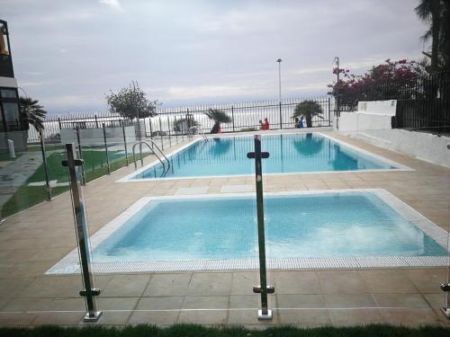 英格兰海滩Apartamentos Corona Playa的毗邻大海的大型游泳池