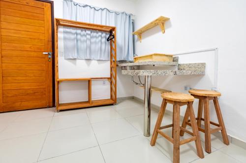纳塔尔Encanto da Praia hotel pousada的厨房配有水槽和2张凳子