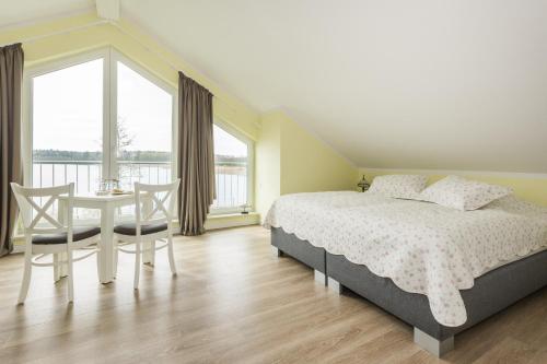 滨湖克拉科Luxus-See-Domizil mit Sauna, Kamin und Boot-130 qm für 6 Personen的卧室配有一张床和一张桌子及椅子