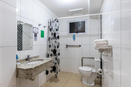 伊瓜苏巴维拉伊瓜苏酒店的一间带卫生间和水槽的浴室以及一台电视。