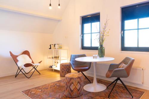 卢特伦De Gouden Wilg的客厅配有桌椅和窗户。