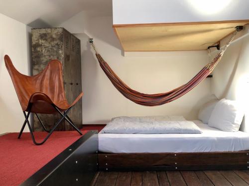 汉堡Schiffshotel "Schlafen im Hafen"的一间卧室配有吊床、一张床和一把椅子