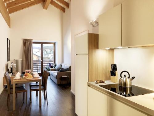 拉瓦罗内Residence Aurora的厨房以及带茶壶和桌子的客厅。