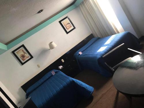 莱昂Hotel Real Rex的一间卧室配有蓝色的床和沙发