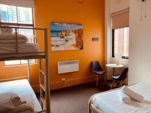 墨尔本YHA Melbourne Central的带两张双层床的客房和一间带橙色墙壁的卧室