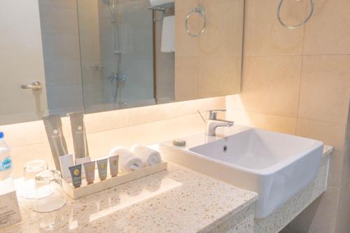 CalasiaoThe Monarch Hotel的一间带水槽和镜子的浴室