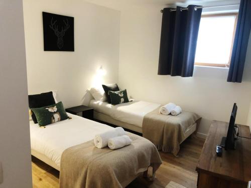 夏蒙尼-勃朗峰Yeti Lodge Chalets & Apartments的一间设有两张床铺和毛巾的房间