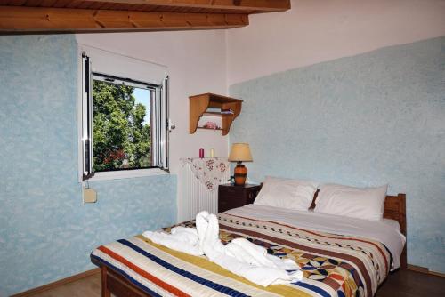 KántanosVilla Areti - A Cottage in the Cretan Nature的一间卧室配有一张带白色床单的床和一扇窗户。