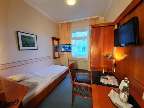 巴特诺因阿尔-阿尔韦勒克鲁博酒店的酒店客房设有一张床、一张书桌和一台电视机。