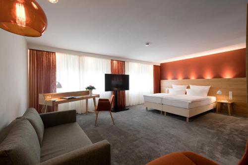 阿斯佩格Hotel Adler Asperg的酒店客房,配有床和沙发