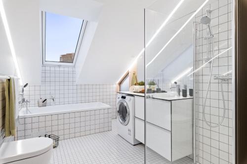 奥斯陆BJØRVIKA APARTMENTS - Solli的白色的浴室内配有洗衣机。
