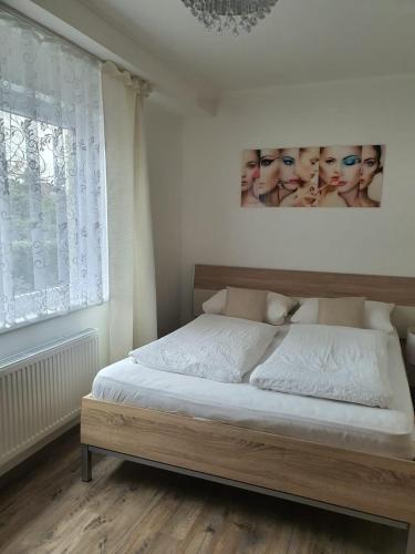 朗根哈根Hotel Schneider Apartaments的卧室配有一张床,墙上挂有绘画作品