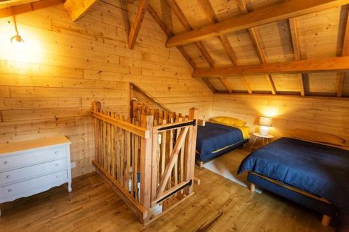 孔东Château des Fousseries的小木屋内一间卧室,配有两张床