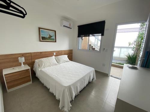朱奎Flat Novinho Em Juquehy的卧室配有白色的床和窗户。