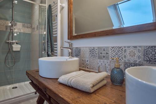 埃尔盖加贝里克A l'Ombre des Pommiers的浴室配有盥洗盆、镜子和浴缸