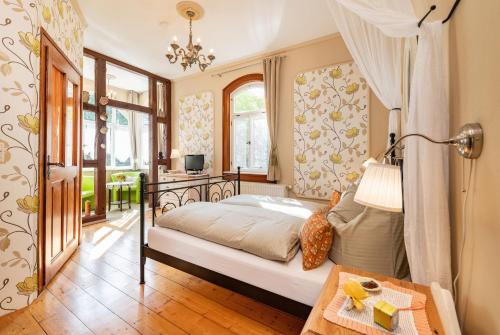 巴特利本施泰因罗斯可别墅酒店的一间卧室配有一张床和一张桌子