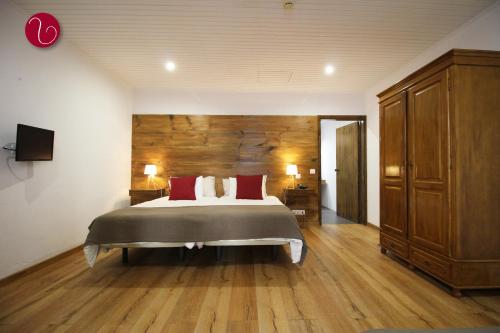 丰沙尔GuestHouse Vila Lusitania的一间卧室设有一张大床和木墙