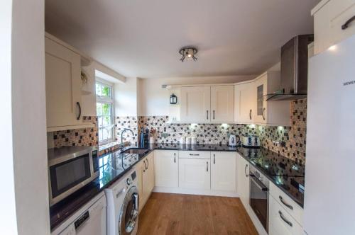 诺丁汉Bagels的厨房配有白色橱柜、洗衣机和烘干机