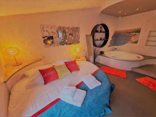 诺亚芒提亚La Chaize - Villa, Suites & Spa的一间卧室设有一张大床和一个浴缸
