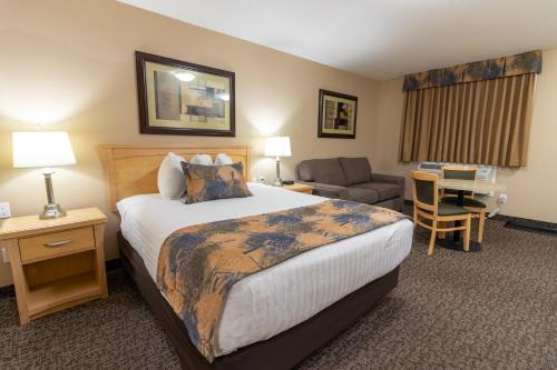 麦克默里堡BC敏思 - 麦克默里堡 - 如斯提汽车旅馆的酒店客房配有一张床、一把椅子和一张书桌