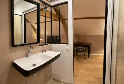 AumontL'Atelier des Magnolias的一间带水槽和镜子的浴室