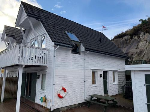 Steinsbø8 person holiday home in Urangsv g的带阳台和野餐桌的白色房屋