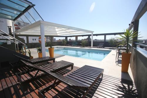 圣米格尔·德·图库玛二百年套房水疗酒店的一个带两把椅子的庭院和一个游泳池