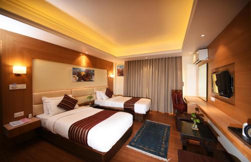 博卡拉中道水疗酒店的酒店客房设有两张床和电视。